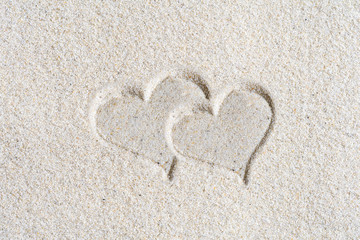 Fototapeta na wymiar Two Drawn Valentines heart on the sand at the beach. Concept