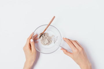 Flat lay female's hands pouring water into bowl