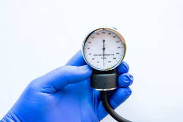 Medical professional, nurse or doctor holds in hand, wearing blue medical glove, sphygmomanometer...
