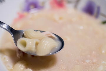 Elbow macaroni soup with spoon