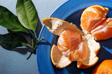 Fresh mandarin oranges fruit or tangerines with leaves on the table.