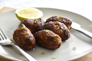 Sheftalia : Cypriot Lamb and Pork Sausages. Traditional Cypriot food. Grilled sausages on white plate.