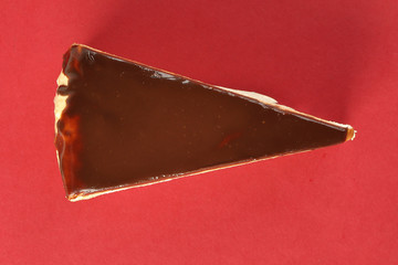 Chocolate crepe layer cake slice top view red background