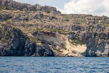 View from a motor boat on the mediterranean sea at the rocky coastline near Stegna on the eastside...