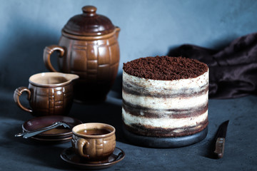 Dessert chocolate cake with cream and chocolate chips, tiramisu on a blue gray dark background