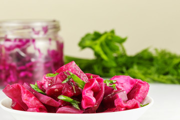 Fermented cabbage with beets lies on a white plate