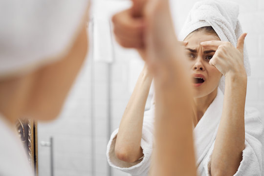 Woman Applying Cream On Her Face