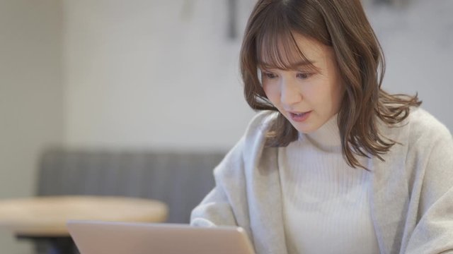 カフェでノートパソコンを操作している女性