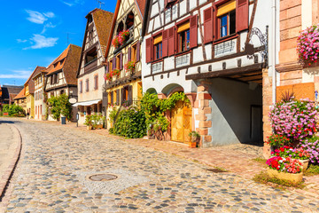 Beautiful facades of houses decorated with flowers on street of Bergheim village, Alsace wine route, France