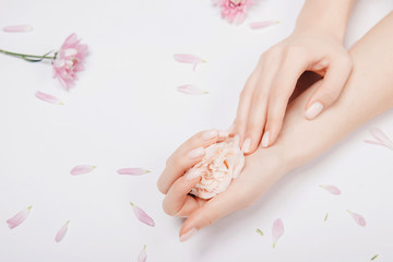 Fototapeta na wymiar Beautiful stylish trendy female pink manicure with flower on background, top view. Concept beauty