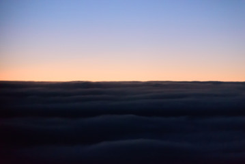 Fototapeta na wymiar The blue skyline with cloudy in sunrise time, view from window on the plane.