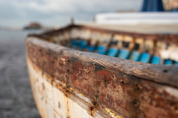 Decrepit old row boats in the harbor in Naples, Italy during the morning following a rain storm.