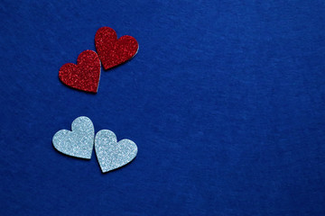 two red and two silver hearts  on classic blue background in trendy color of year. Copy space.