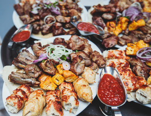 Variety assortment of traditional main course meat barbecue grill dishes of Caucasian cuisine, with shashlik on skewer, Lyulya kebab, kebab, Azerbaijani cuisine