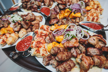 Variety assortment of traditional main course meat barbecue grill dishes of Caucasian cuisine, with shashlik on skewer, Lyulya kebab, kebab, Azerbaijani cuisine