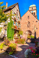 Fototapeta na wymiar Beautiful church and traditional colorful houses in picturesque Kaysersberg village, Alsace wine region, France