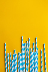 Blue cocktail straws on a yellow background
