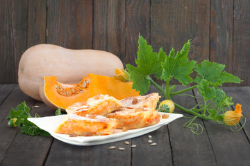 Traditional Serbian pumpkin strudel served on white plate. Butternut pumpkin cake on rustic wooden background.