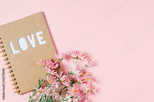 Beautiful flowers composition. Pink flowers chamomile, notebook on pastel pink background. Valentines Day, Happy Women's Day, Mother's day. Flat lay, top view, copy space