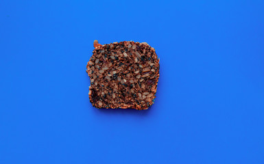 Sliced whole grain bread rye with seeds flax, sunflower, pumpkin and sesame.Healthy food, eco-friendly natural products. Fresh bread on a classic blue background.