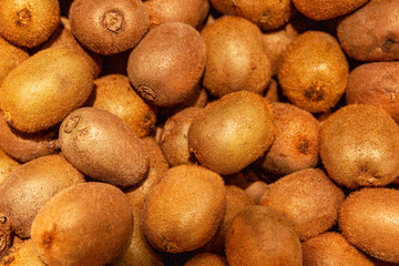 A lot of kiwi on the counter in the supermarket. Vitamins and health. Close-up. Background. Space...