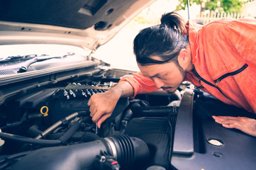 View of a Young attractive mechanic working on a car at the garage