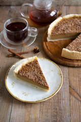 A piece of delicious pumpkin cheesecake with chocolate on a beautiful plate and a Cup of fragrant tea. Vertical photo
