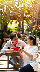 young happy couple with present at public park