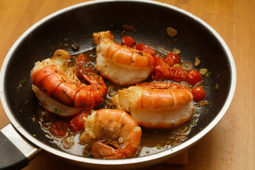 King prawns in a pan with tomatos and herbs