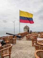 Terrace of cafe near the sea with the colombian flag