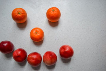 Four fruits: mangoes, oranges, tangerines and peaches (nectarines) on a table 