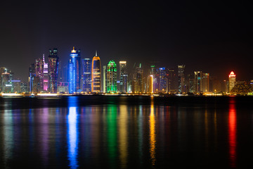 Fototapeta na wymiar Vibrant Skyline of Doha at Night as seen from the opposite side of the capital city bay at night