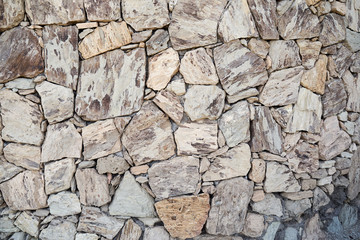 Beschaffenheit einer grauen Natursteinmauer als abstrakter Hintergrund