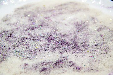 A purple glitter with sugar. Composition with glitter and sugar against background. Beautiful and textured background.
