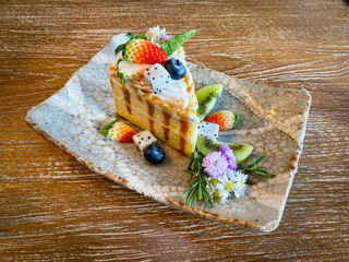 Beautiful cake with fruits placed on the wood table