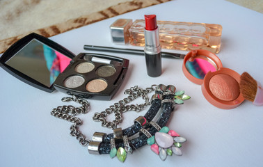 UK, Hove, 7/12/2019: Layout of perfume Boss, eyeshadows and blush, a necklace in black with bright...