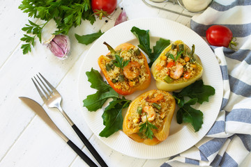 Vegetarian dish. Peppers stuffed with quinoa, shrimp  and vegetables on white wooden table.