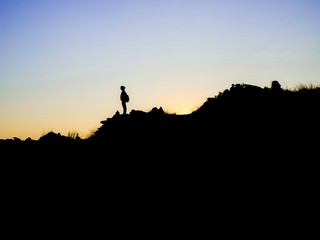 silhouette of man on top of mountain
