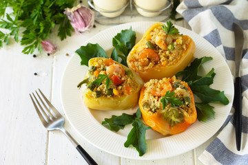 Vegetarian dish. Peppers stuffed with quinoa, shrimp  and vegetables on white wooden table.