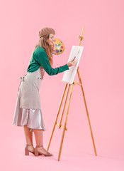Young female artist on color background