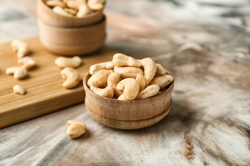 Bowl with tasty cashew nuts on table