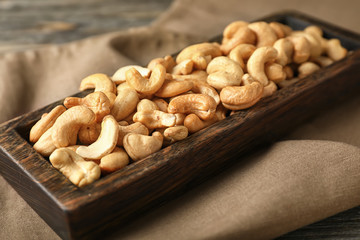 Stand with cashew nuts on table, closeup