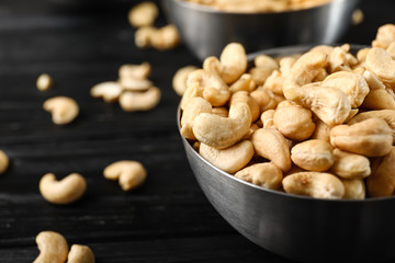 Bowl with cashew nuts on table, closeup