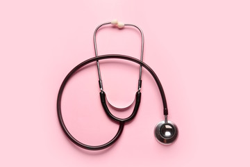 Modern stethoscope on color background