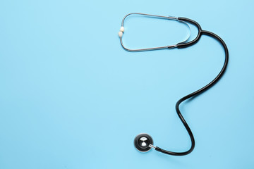 Modern stethoscope on color background