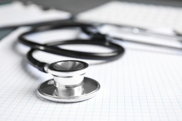 Stethoscope and notebook on table, closeup