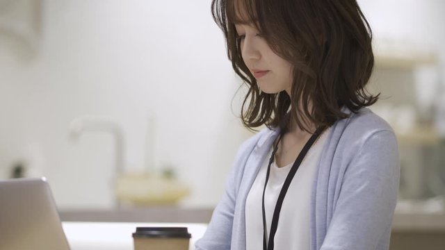 カフェでノートパソコンを操作している女性