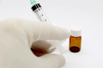 Disposable syringe, latex gloves and vials isolated on white background
