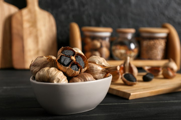 Bowl with black garlic on kitchen table