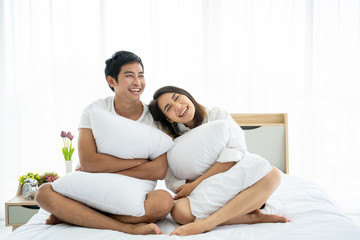 Happy Asian couple staying together in the bedroom.